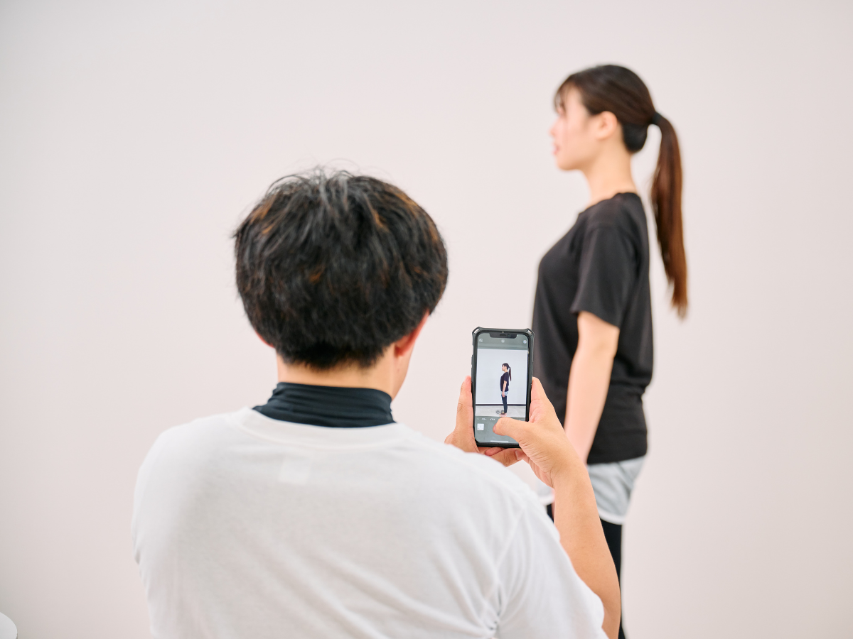 トレーナーが横向きの姿勢を確認する様子